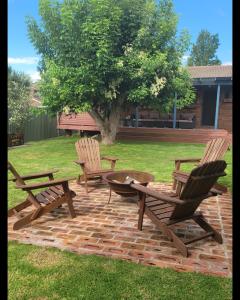 2 stoelen en een vuurplaats op een bakstenen patio bij Blue Wren BnB Bathurst in Bathurst