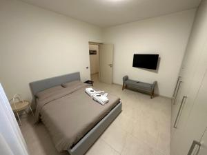 una camera con letto e TV a schermo piatto di CasaVALE ELEGANTE RESIDENZA 108 mq MAX 7 PERSONE a Piacenza
