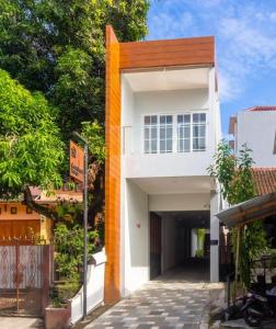 een wit en oranje gebouw met een garage bij Cendhani Raras Residence in Demangan