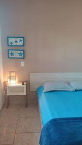 - une chambre avec un lit et une table de chevet éclairée dans l'établissement Bella Praia apartamento Estrela do mar, à Passo de Torres