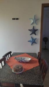 Bella Praia apartamento Estrela do mar في باسو دي توريس: طاولة طعام مع نجوم على الحائط