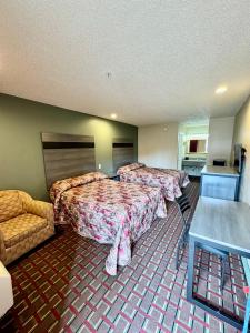 a hotel room with two beds and a couch at Seagoville Inn in Seagoville