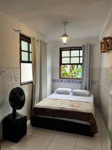 a bedroom with a bed and a window at Hostel Uai in Ouro Preto