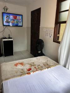 a bedroom with a bed and a tv and a window at Hostel Uai in Ouro Preto