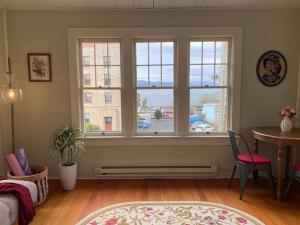 uma sala de estar com uma janela, uma mesa e cadeiras em Historic Downtown Riverview Flat, No 3 em Astoria