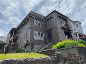 a large brown house on top of a hill at Historic Downtown Riverview Flat, No 3 in Astoria, Oregon