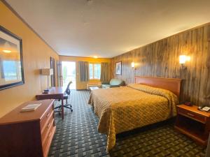 Pokój hotelowy z łóżkiem i biurkiem w obiekcie Tennessee Mountain Lodge w mieście Pigeon Forge