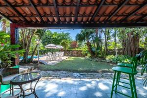 a patio with a table and chairs and a yard at Positano Ilhabela Lodges in Ilhabela