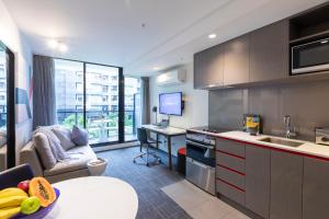 a kitchen with a table and a desk in a room at Corporate Living Accommodation Abbotsford in Melbourne