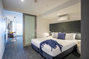 a hotel room with a large bed and a desk at Corporate Living Accommodation Abbotsford in Melbourne