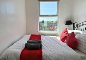 - une chambre avec un grand lit et des oreillers rouges dans l'établissement Relaxing Getaway For Families With Free Parking, à Liverpool
