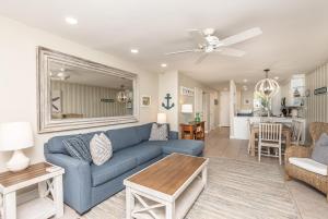 a living room with a blue couch and a table at D-31 Beachfront Bliss in Oceanside