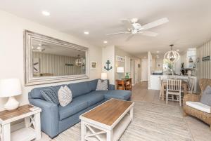Una sala de estar con un sofá azul y una mesa. en Holiday Getaway-Beachfront Views 2 Pools 3 Spas, en Oceanside