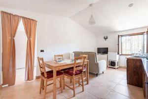 een woonkamer met een houten tafel en stoelen bij La mansardina di nonno Biagio in Bastia Umbra