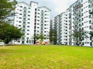 un parque con edificios de apartamentos altos y un parque infantil en HomeSTAY PANGSAPURI SAMUDERA SERI MANJUNG LUMUT, en Seri Manjung