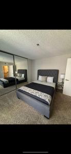 1 dormitorio con 1 cama grande y espejo en Incredible Two Bedroom Hollywood Apartments FREE Parking, en Los Ángeles