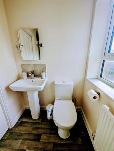 y baño con aseo y lavamanos. en Modern Comfy 3 Bed Home - Free 2 space driveway and free road parking en Derby