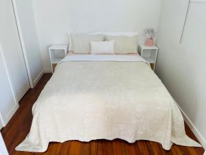 ein Schlafzimmer mit einem Bett mit einer weißen Tagesdecke in der Unterkunft Sunny Modern Cottage - Close to Airport in Napier