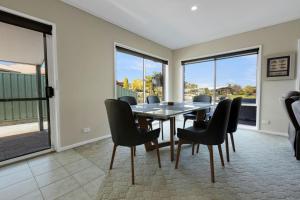 a dining room with a table and chairs and windows at Clipper Cove in Paynesville