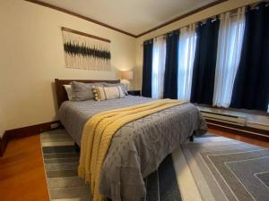 um quarto com uma cama grande e cortinas azuis em Historic Downtown Riverview Flat, No. 4 em Astoria