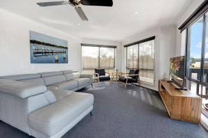 Una sala de estar con un sofá blanco y una mesa. en Mimada Escape, en Lakes Entrance