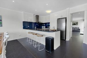 una cocina con armarios azules y blancos y una encimera en Mimada Escape, en Lakes Entrance