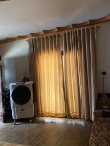 a living room with curtains and a fan at Cozy Private Apartment in Asyut