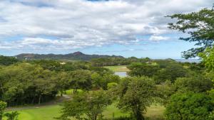 uma vista para um parque com árvores e um lago em Boungainvillea 1203 Luxury Apartment - Reserva Conchal em Playa Conchal
