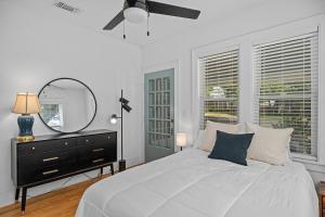 ein Schlafzimmer mit einem Bett mit Spiegel und einer Kommode in der Unterkunft House on Cora - Sleeps 10 Hot Tub & Walk to Main in Fredericksburg + 75 Fotos