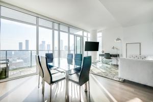 a dining room with a glass table and chairs at Epic 2BR Condo w/ Panoramic CN Tower/City View in Toronto