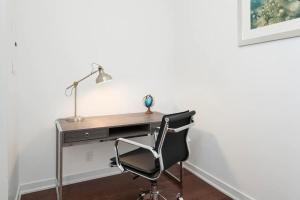 um escritório com uma secretária com uma cadeira e um candeeiro em Executive 1 BR Condo - CN Tower & City View em Toronto