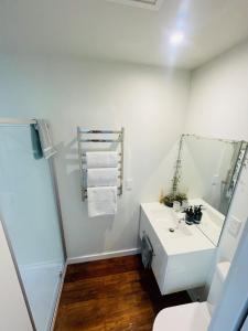 a bathroom with a white sink and a shower at Sunny Modern Cottage - Close to Airport in Napier