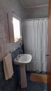 een badkamer met een wastafel en een douchegordijn bij Alamafuerte in San Pedro