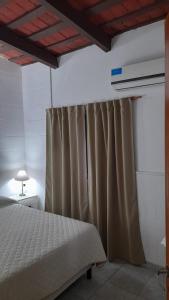 1 dormitorio con cama y cortina en Alamafuerte en San Pedro