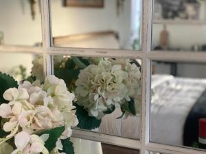 a vase filled with white flowers in a window at Luxury winter escape with Mountain Views by Scotch Hill Truffle Farm in Neerim South