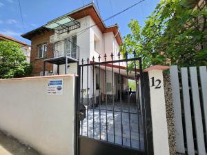 a gate in front of a house with a building at PANORAMNA -Guest Rooms in Veliko Tŭrnovo