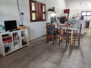 een keuken en eetkamer met een tafel en stoelen bij Paraíso do Brutus - casa de temporada in Beberibe