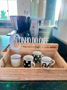 a wooden crate with four coffee cups and a blender at Central Praias III in Cabo Frio