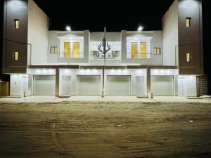 - un bâtiment avec deux portes de garage et une horloge dans l'établissement Agharina furnished apartments, à Nouakchott