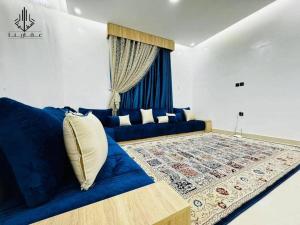 - un salon avec un canapé bleu et une fenêtre dans l'établissement Agharina furnished apartments, à Nouakchott