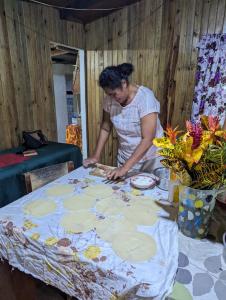 una donna in piedi a un tavolo con una tovaglia di AerowView Home Retreat a Matei