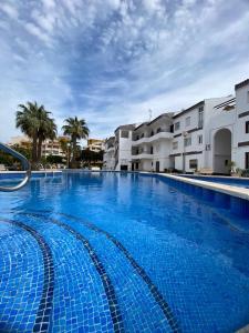 a large blue swimming pool with buildings in the background at Punta Prima Gataway in Torrevieja