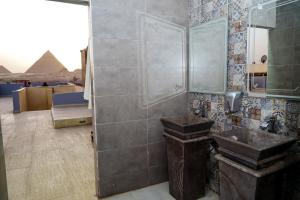 uma casa de banho com um lavatório e uma pirâmide em Pyramids Hotel no Cairo