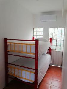 um quarto com um beliche com almofadas brancas em La casa 19 em Cancún