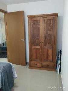 un armario de madera junto a una puerta en una habitación en 2 Quartos Novíssimo na Praia de Itaparica com PISCINA e SAUNA, en Vila Velha