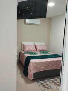 1 dormitorio con 1 cama y TV en la pared en 2 Quartos Novíssimo na Praia de Itaparica com PISCINA e SAUNA, en Vila Velha