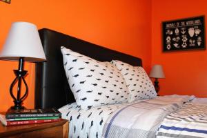 una camera con un letto con una parete arancione di Riverfront Property in NRG National Park near Sandstone Falls- Wi-Fi, Pet-Friendly a Hinton