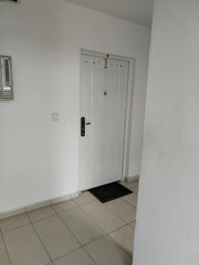 um corredor com uma porta branca e piso em azulejo em Silver night 