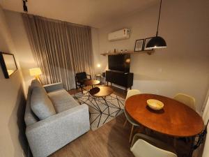 uma sala de estar com um sofá e uma mesa em Apartamento Modernizado no Rio de Janeiro