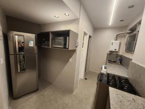a small kitchen with a refrigerator and a microwave at Apartamento Modernizado in Rio de Janeiro